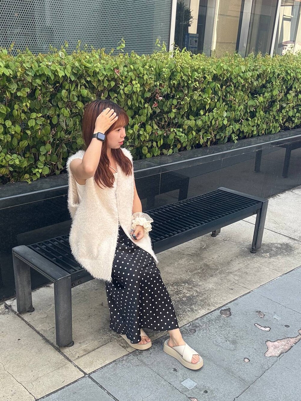 ホワイト系のサンダル、ベージュ系のキャミソール、ブラック系のスカートを着用したレディースの夏コーディネートの2枚目の写真