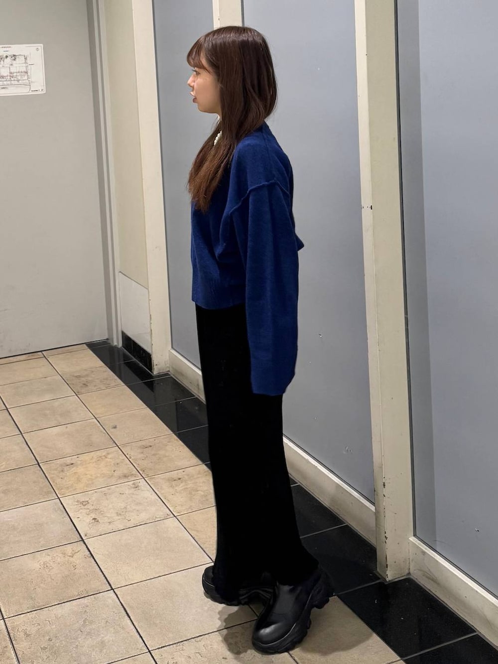 ブラック系のブーツ、ブラック系のスカート、ブルー系のTシャツ/カットソーを着用したレディースの秋コーディネートの2枚目の写真