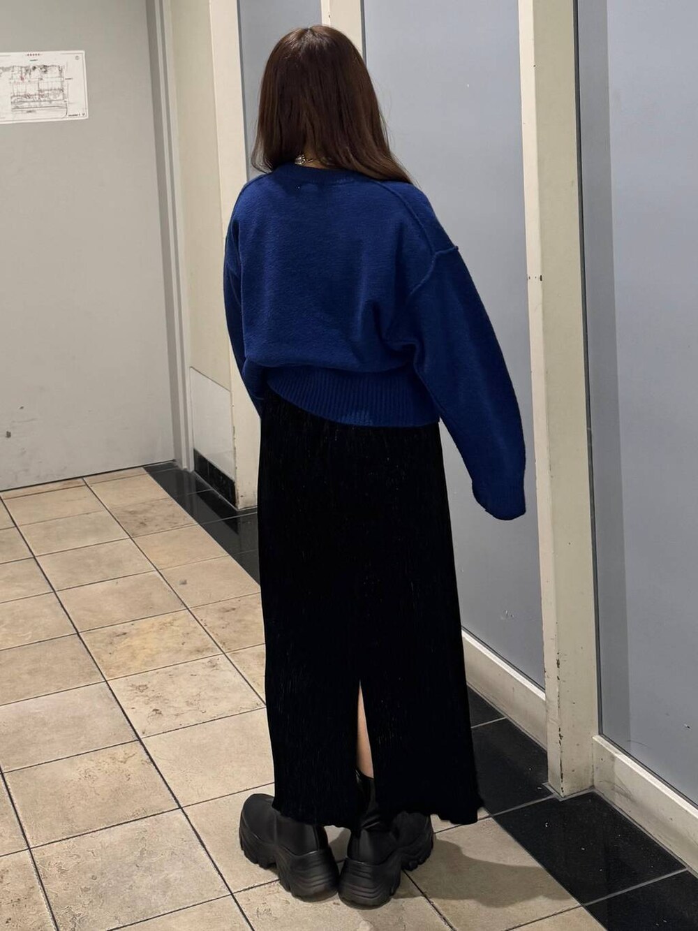 ブラック系のブーツ、ブラック系のスカート、ブルー系のTシャツ/カットソーを着用したレディースの秋コーディネートの3枚目の写真