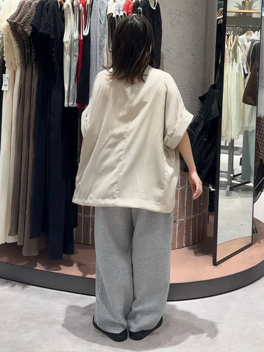 グレー系のスウェットパンツ、ホワイト系のテーラードジャケット、ブラック系のサンダルを着用したレディースの夏コーディネートの3枚目の写真