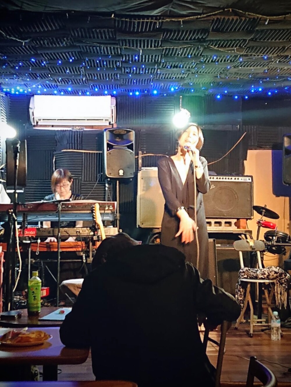 ブラック系のワンピース/ドレス、ベージュ系のジャケット/アウター、レッド系のバッグを着用したレディースの春コーディネートの2枚目の写真