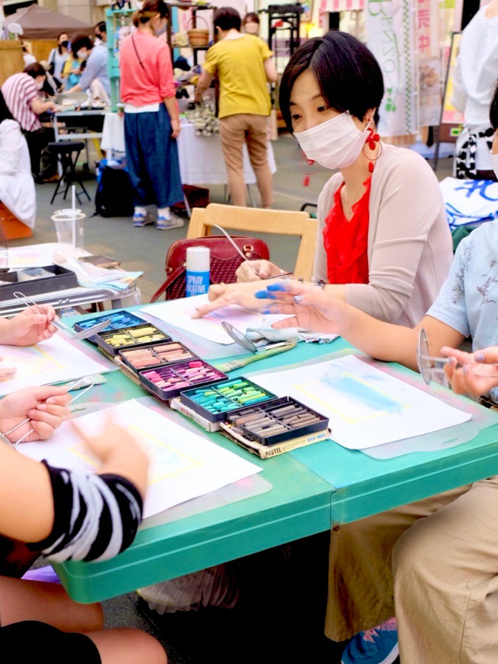 レッド系のトップス、レッド系のバッグ、グレー系のスカートを着用したレディースの秋コーディネートの2枚目の写真