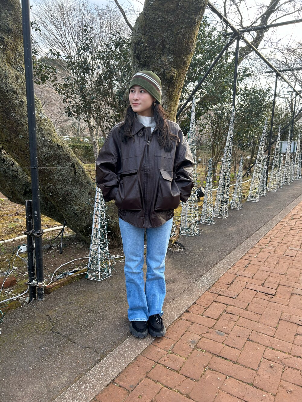 ブラウン系のブルゾン、ブラック系のモカシン/デッキシューズ、ブルー系のデニムパンツを着用したレディースの冬コーディネートの3枚目の写真