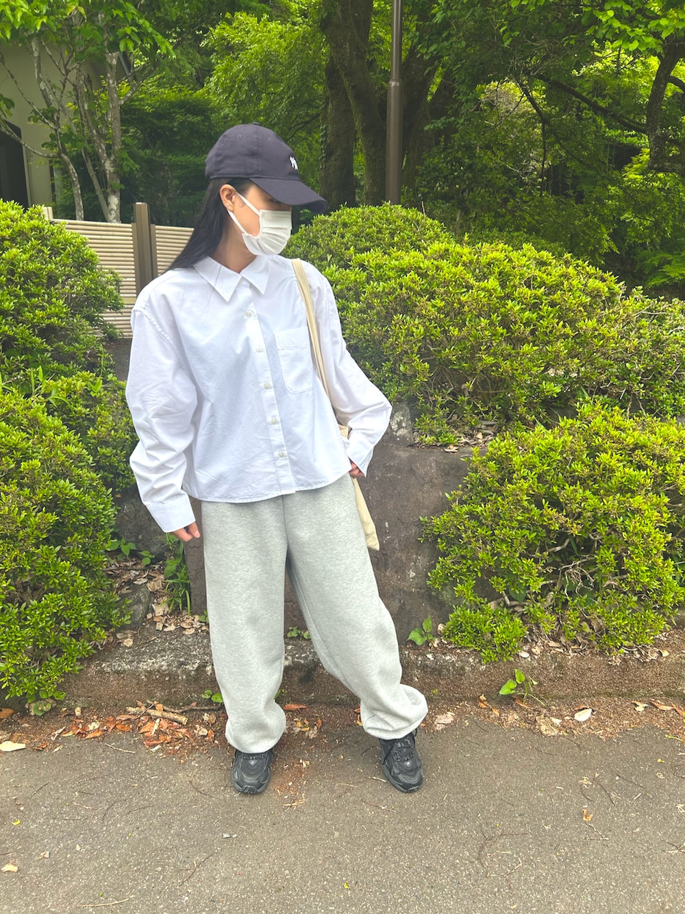 ブラック系のスニーカー、ホワイト系のシャツ/ブラウス、グレー系のスウェットパンツを着用したレディースの夏コーディネートの2枚目の写真