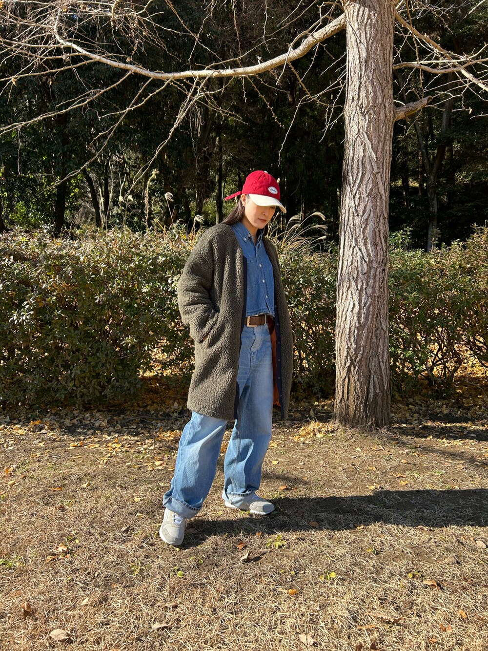 ブルー系のシャツ/ブラウス、ベージュ系のスニーカー、ブラウン系のベルトを着用したレディースの冬コーディネートの2枚目の写真