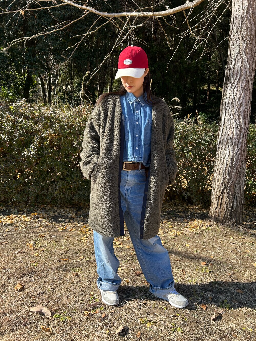 ブルー系のシャツ/ブラウス、ベージュ系のスニーカー、ブラウン系のベルトを着用したレディースの冬コーディネートの3枚目の写真