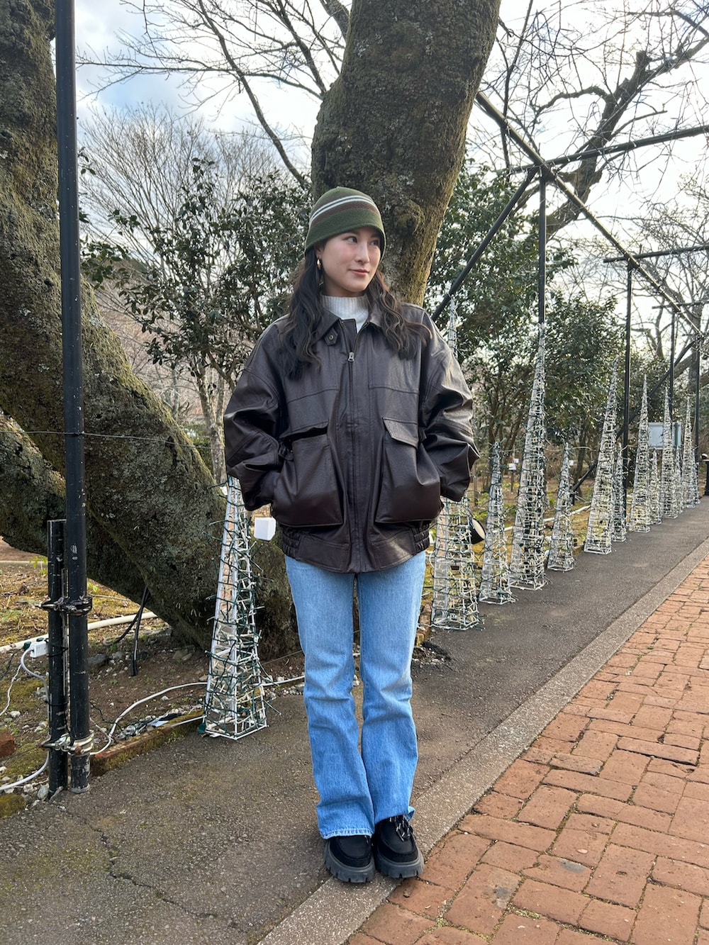 ブラウン系のブルゾン、ブラック系のモカシン/デッキシューズ、ブルー系のデニムパンツを着用したレディースの冬コーディネートの2枚目の写真