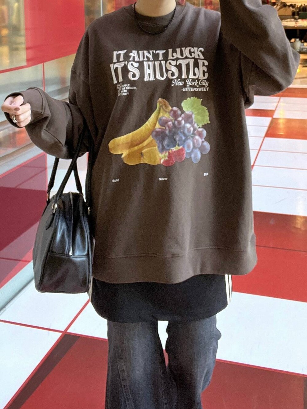 ブルー系のデニムパンツ、ブラック系のスカート、ブラック系のボストンバッグを着用したレディースの秋コーディネートの2枚目の写真