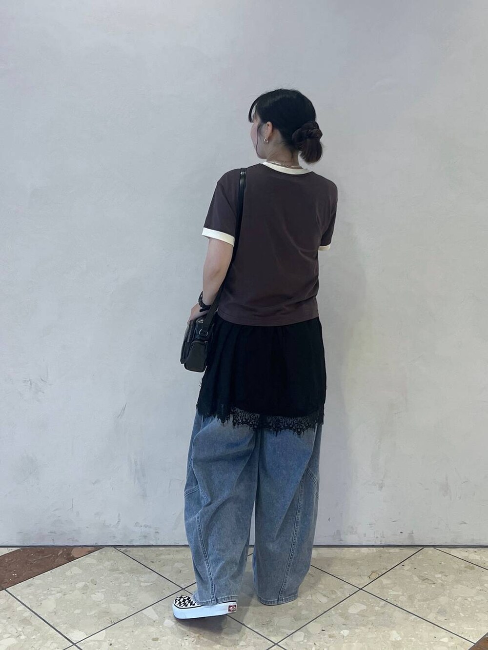 ブラウン系のTシャツ/カットソー、ブルー系のデニムパンツ、ブラック系のショルダーバッグを着用したレディースの夏コーディネートの2枚目の写真