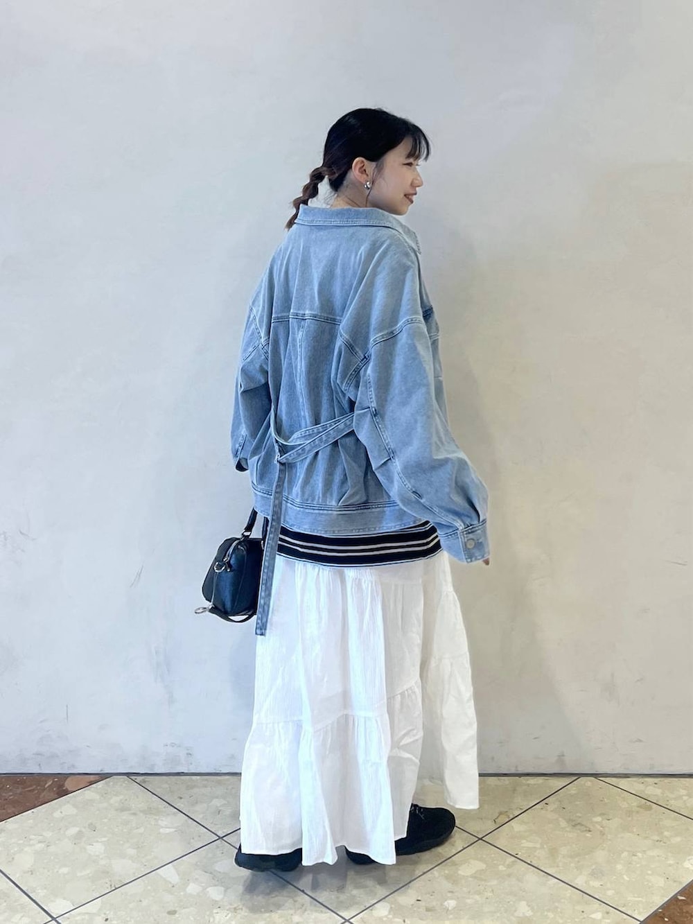 ブルー系のTシャツ/カットソー、ブラック系のボストンバッグ、ブラック系のスニーカーを着用したレディースの冬コーディネートの3枚目の写真