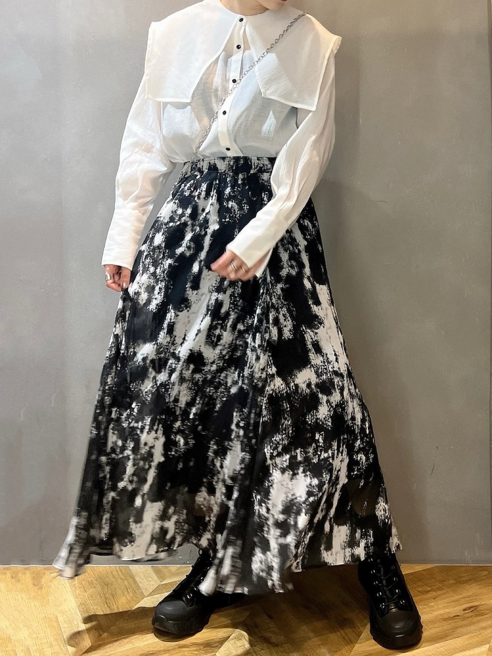 ブラック系のブーツ、ブラック系のスカート、ホワイト系のシャツ/ブラウスを着用したレディースの春コーディネートの3枚目の写真