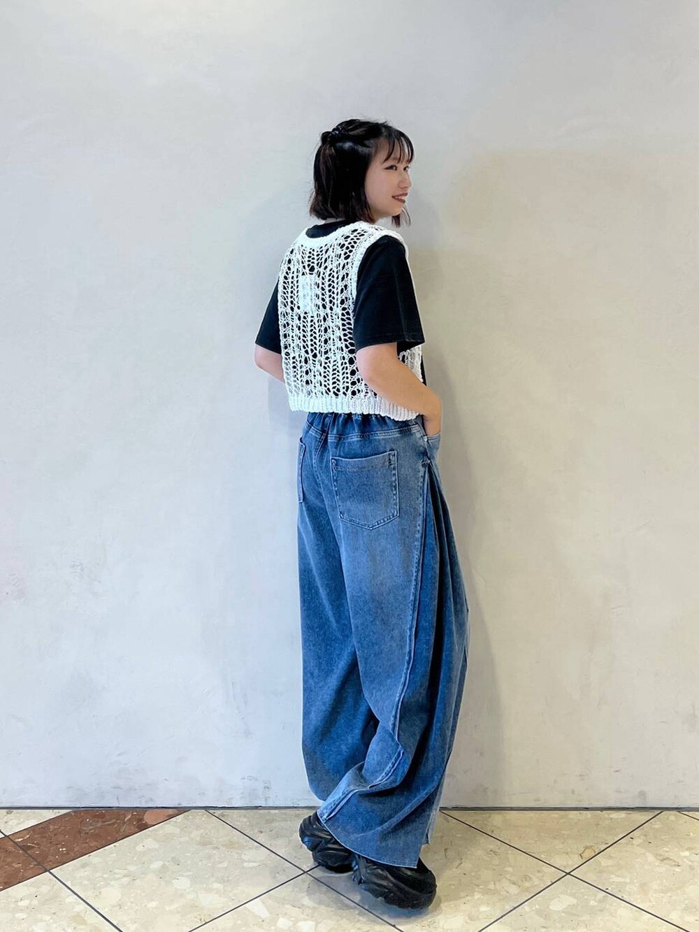 ブラック系のスニーカー、ブルー系のデニムパンツ、ホワイト系のTシャツ/カットソーを着用したレディースの夏コーディネートの2枚目の写真