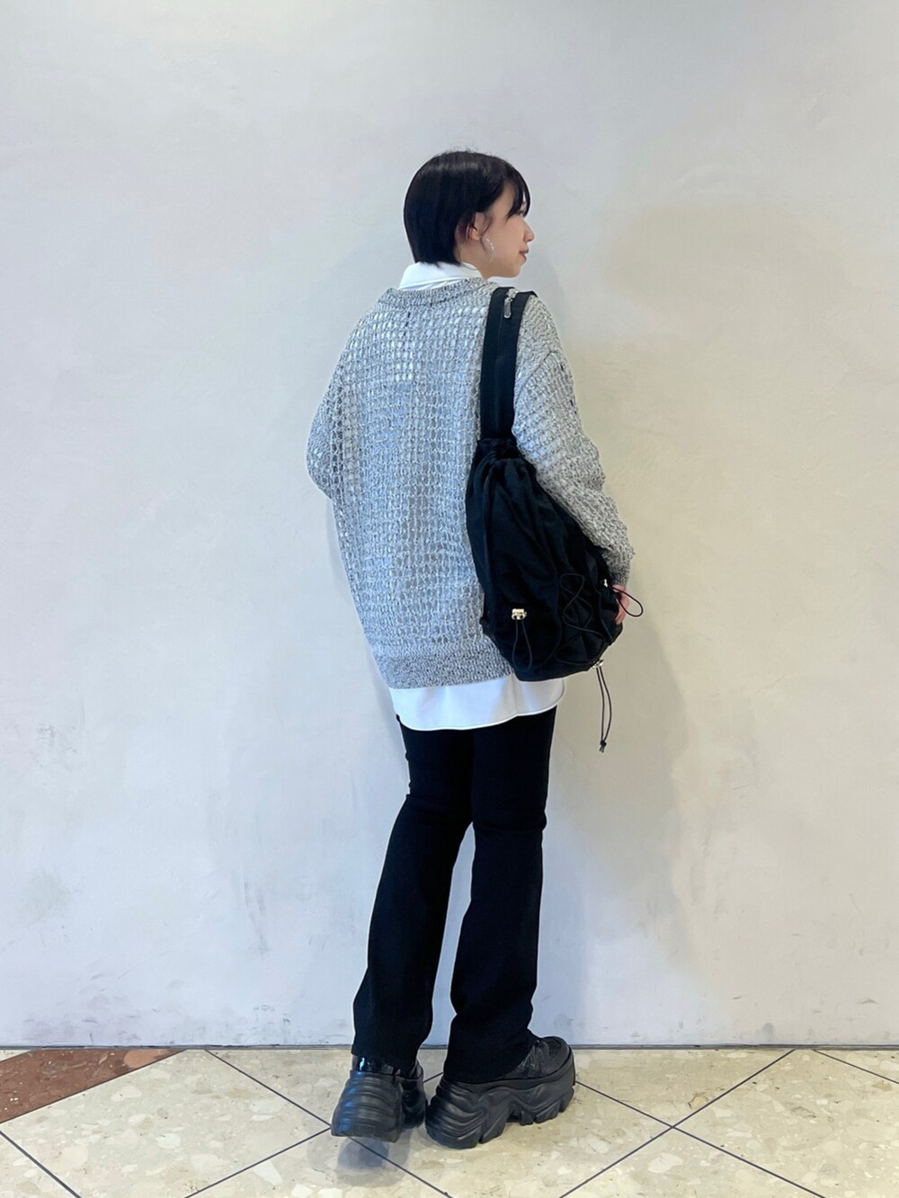 ブラック系のショルダーバッグ、グレー系のカーディガン/ボレロ、ブラック系のデニムパンツを着用したレディースの春コーディネートの4枚目の写真