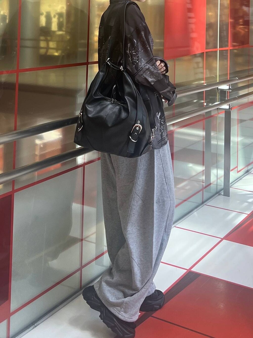 ブラック系のショルダーバッグ、グレー系のスウェットパンツ、ブラック系のシャツ/ブラウスを着用したレディースの夏コーディネートの3枚目の写真