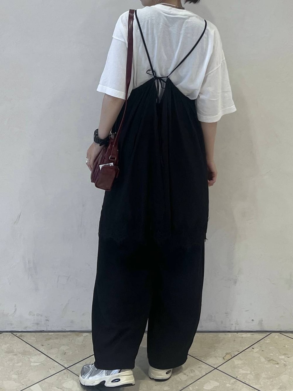 レッド系のショルダーバッグ、ホワイト系のTシャツ/カットソー、ブラック系のスウェットパンツを着用したレディースの夏コーディネートの2枚目の写真