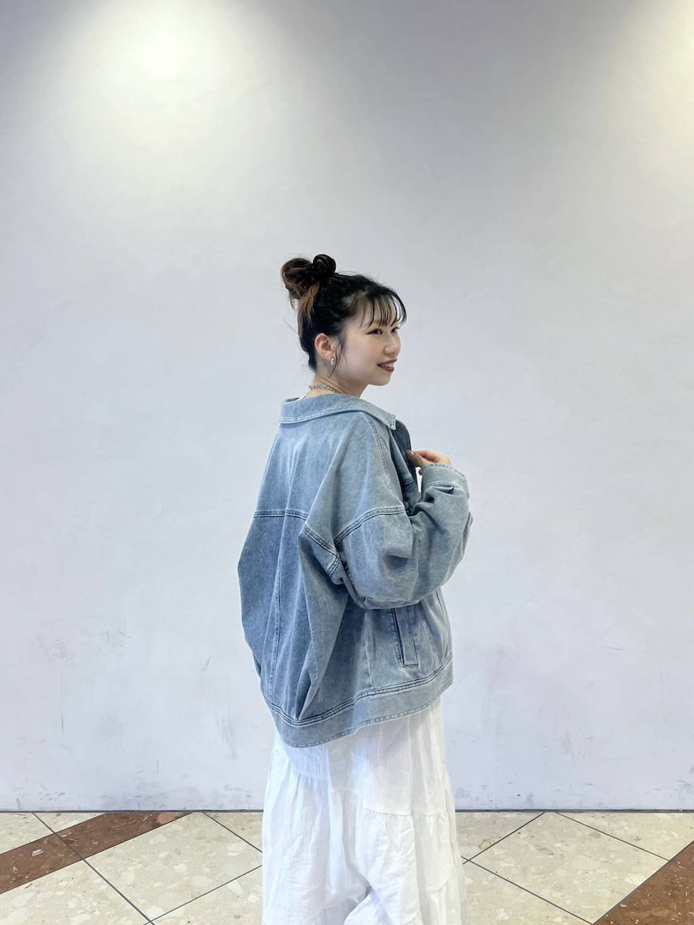 ブルー系のブルゾン、グレー系のショルダーバッグ、ホワイト系のスカートを着用したレディースの冬コーディネートの2枚目の写真