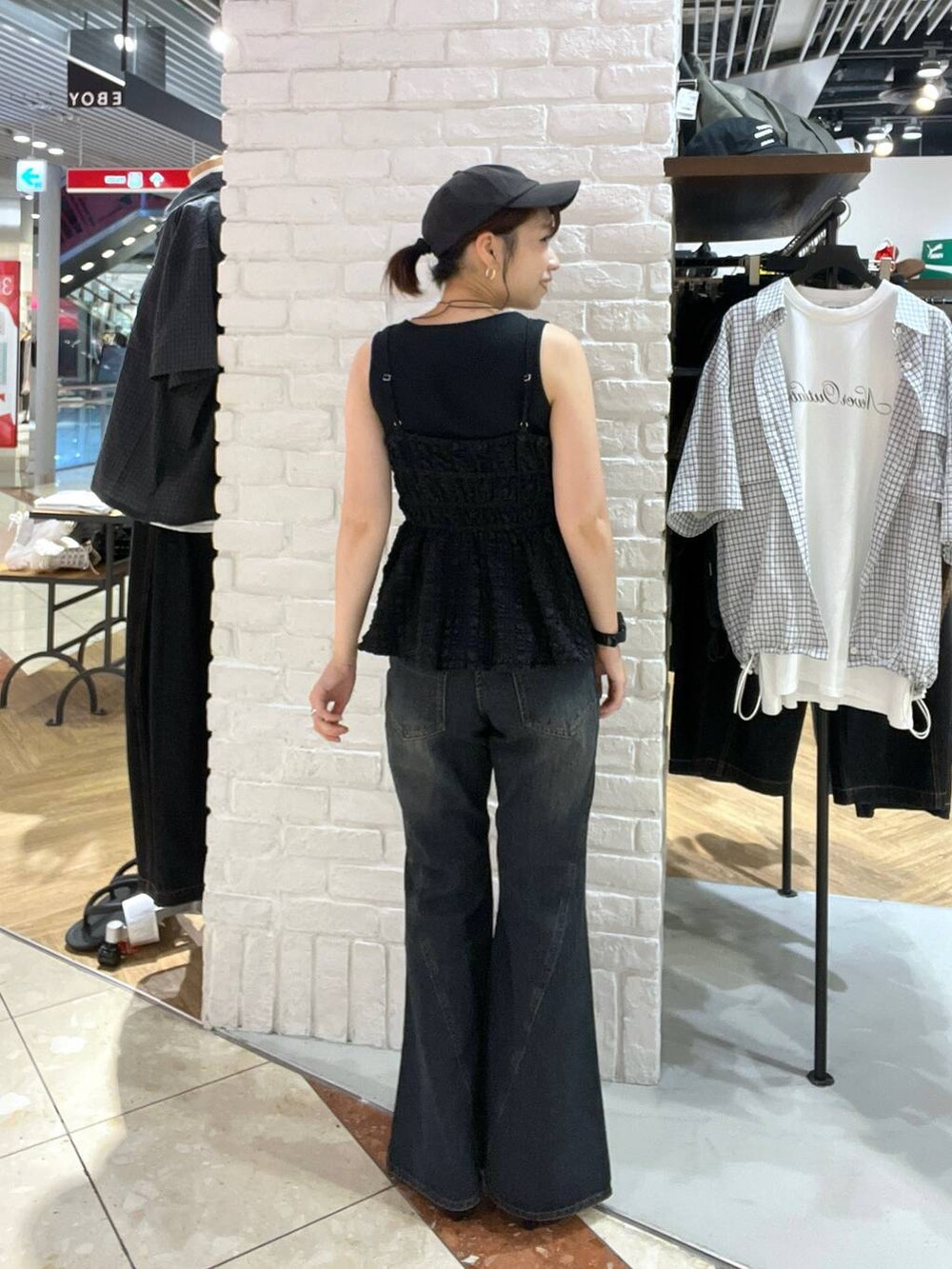 レッド系のサンダル、ブルー系のデニムパンツ、ブラック系のキャミソールを着用したレディースの夏コーディネートの3枚目の写真