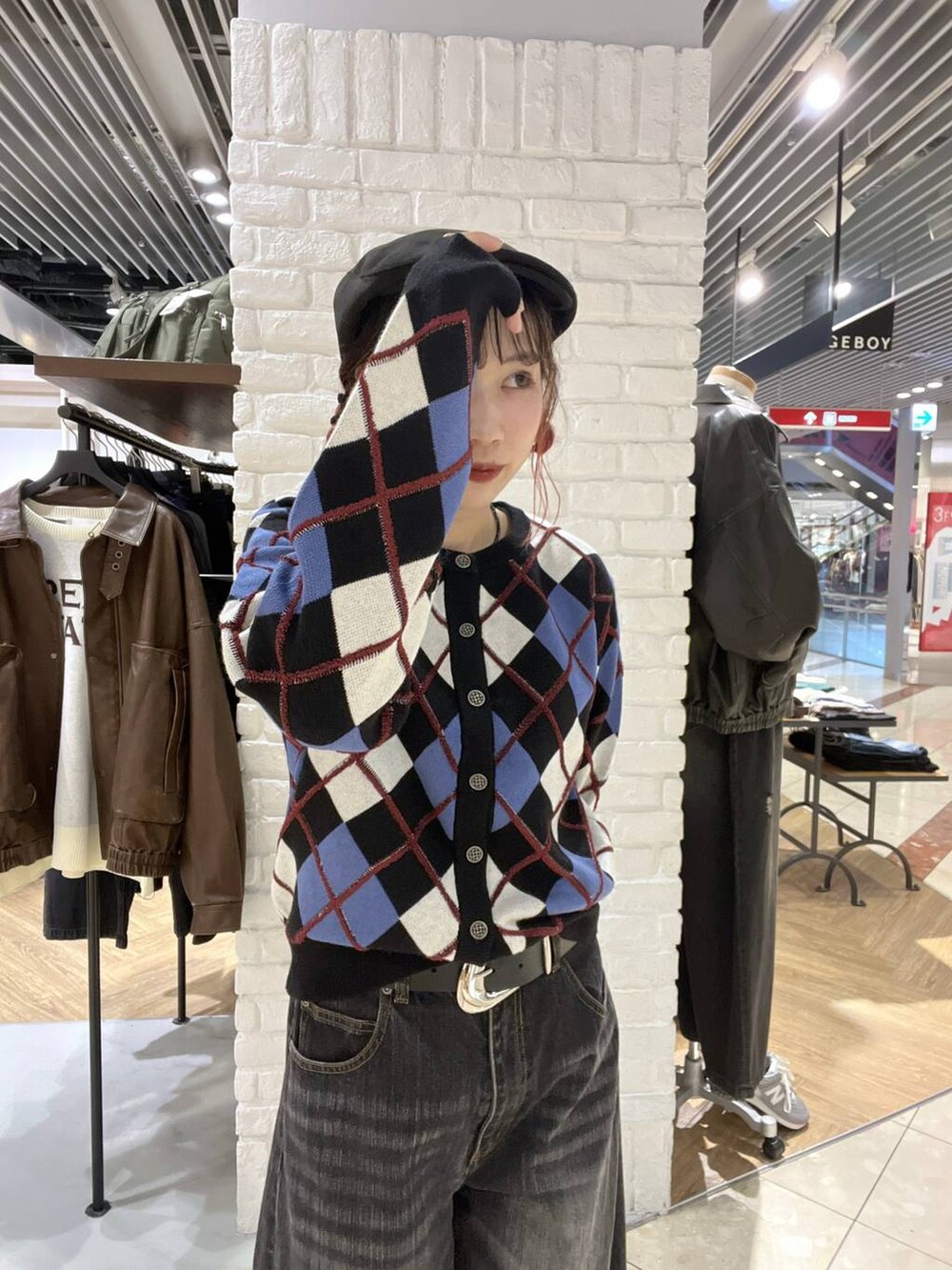 ブラック系のカーディガン/ボレロ、ブラック系のデニムパンツ、ブラック系のベルトを着用したレディースの秋コーディネートの2枚目の写真