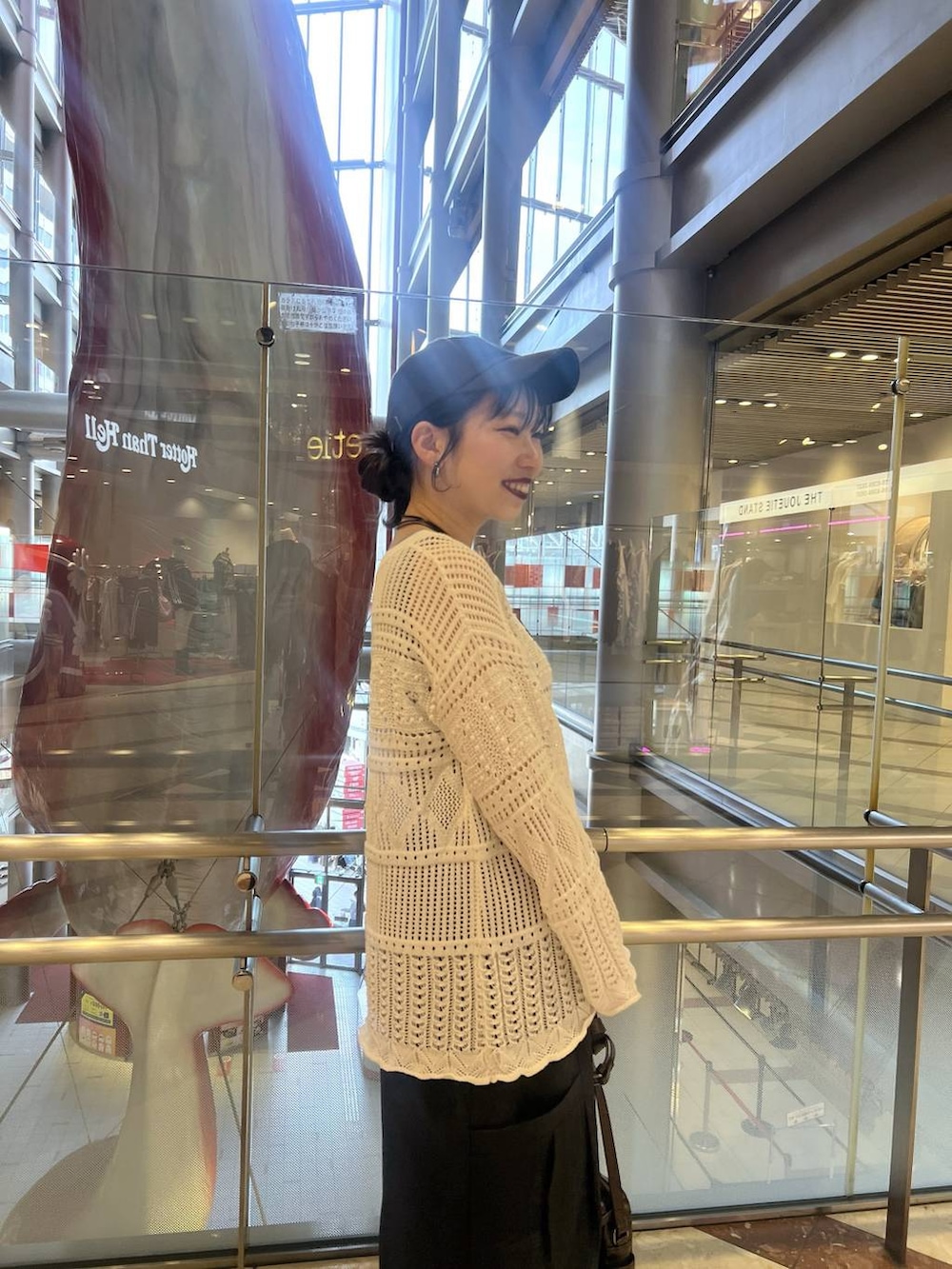 ブルー系のタンクトップ、ブラウン系のショルダーバッグ、ホワイト系のニット/セーターを着用したレディースの春コーディネートの3枚目の写真