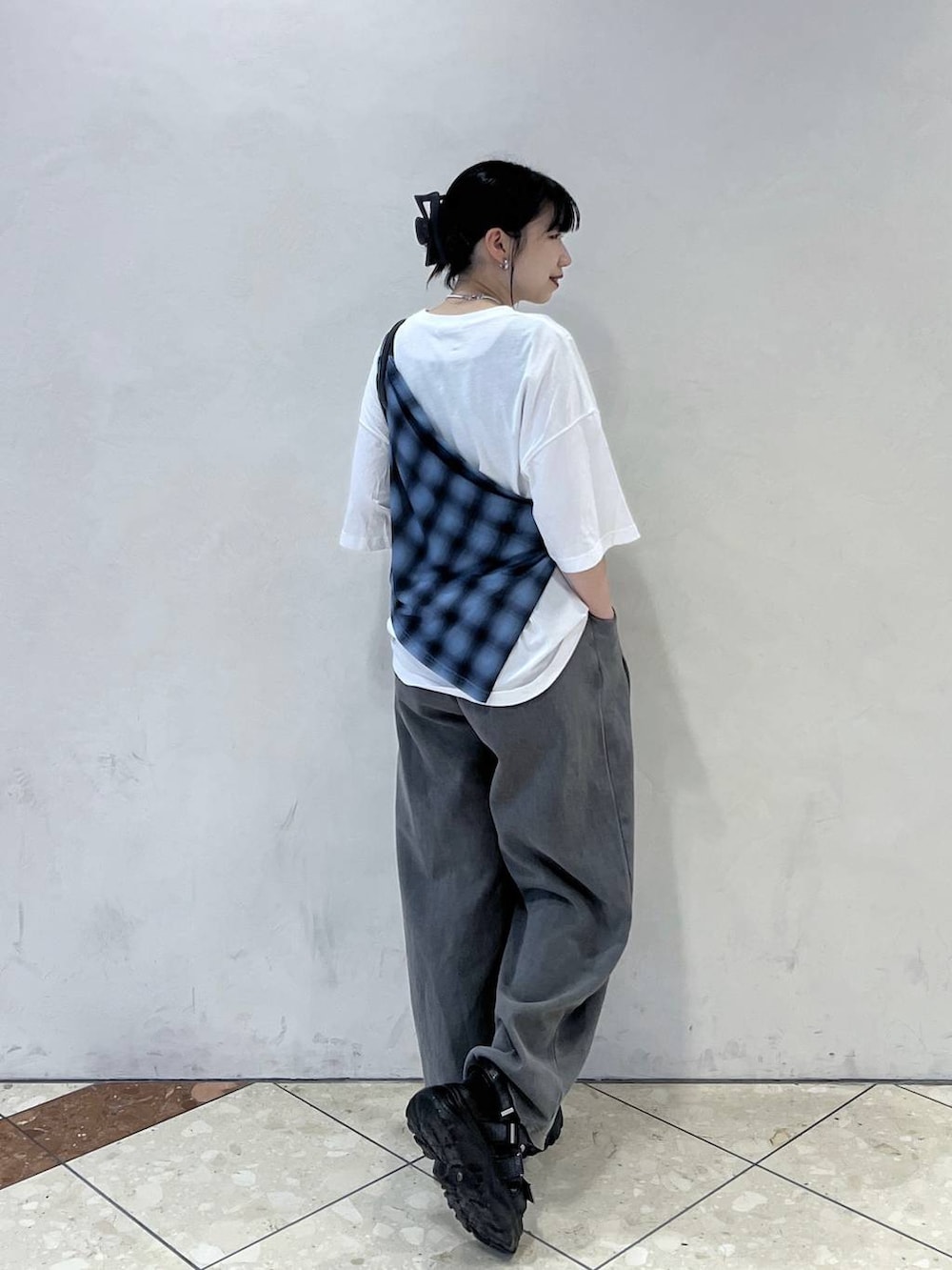 グレー系のスウェットパンツ、ブラック系のショルダーバッグ、ブラック系のサンダルを着用したレディースの春コーディネートの2枚目の写真