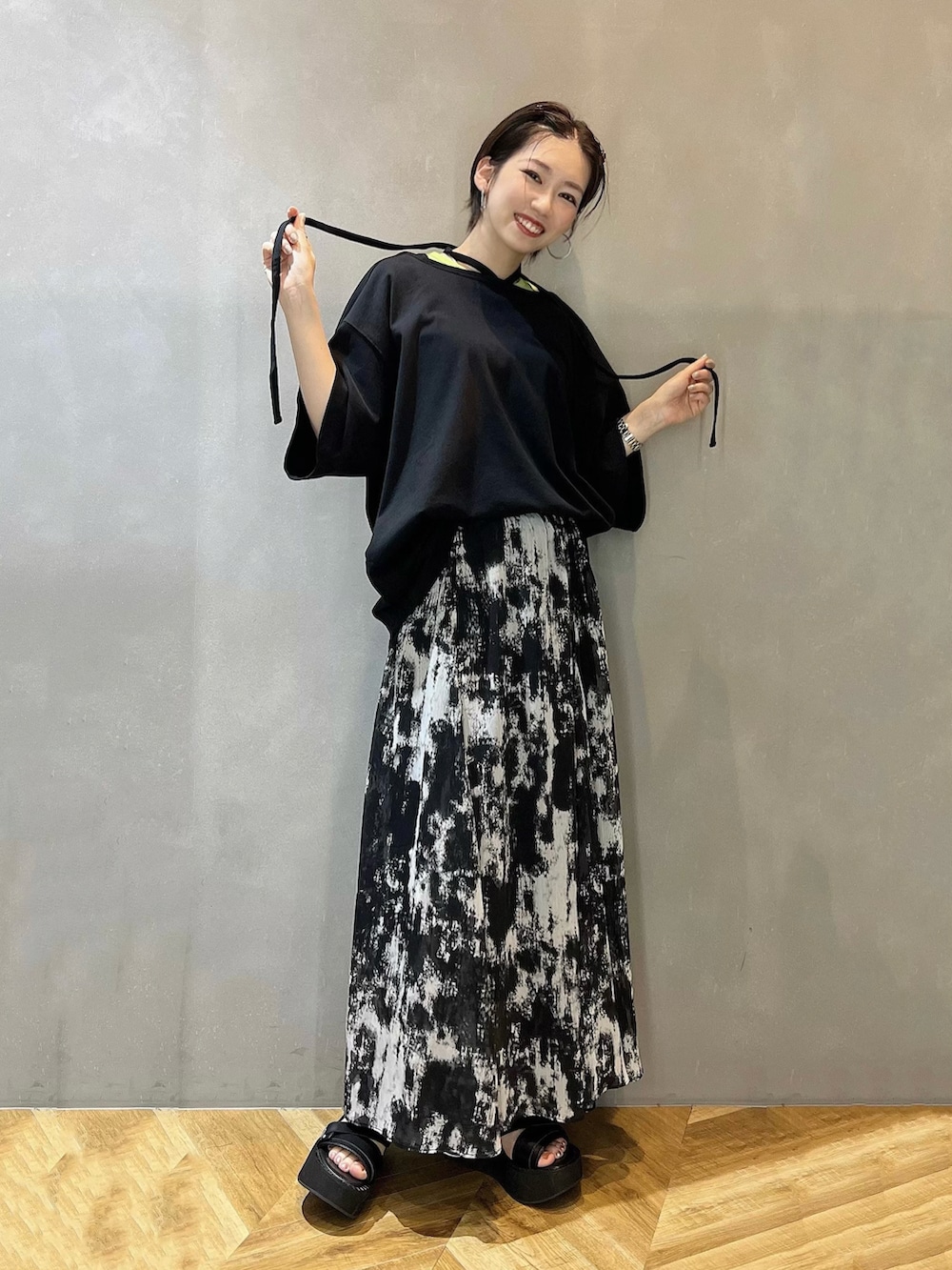 ブラック系のスカート、ブラック系のサンダル、ブラック系のTシャツ/カットソーを着用したレディースの春コーディネートの2枚目の写真