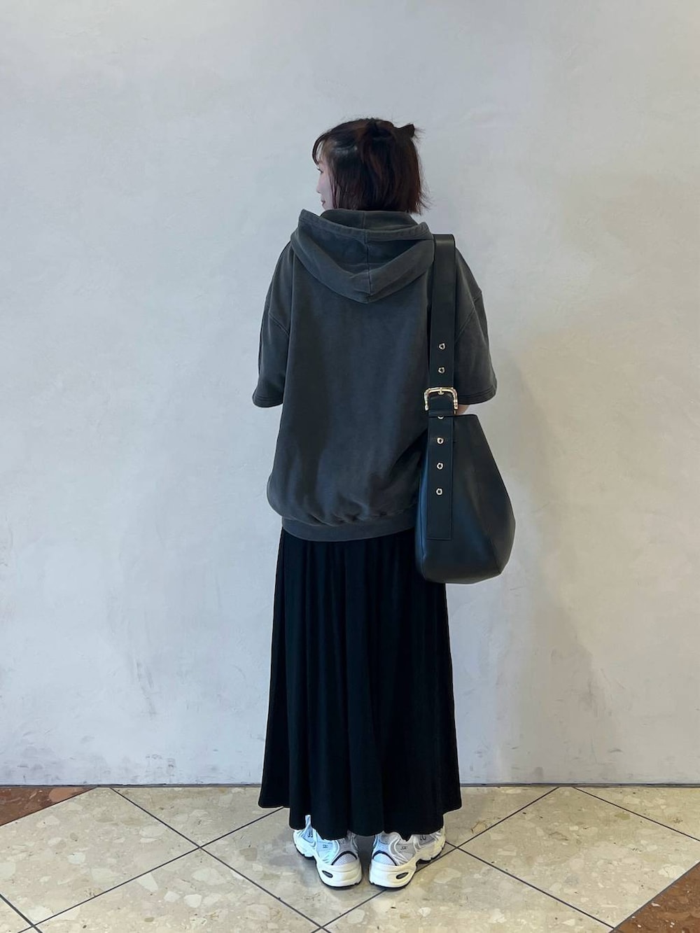 ブラック系のショルダーバッグ、ブラック系のスカート、グレー系のパーカーを着用したレディースの夏コーディネートの2枚目の写真