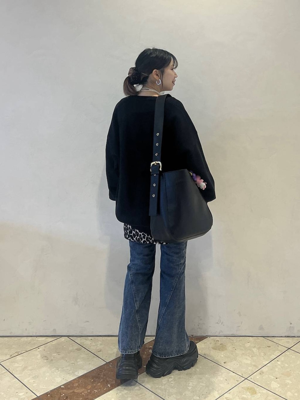 ブラック系のブーツ、ブラック系のニット/セーター、ブラック系のショルダーバッグを着用したレディースの冬コーディネートの3枚目の写真