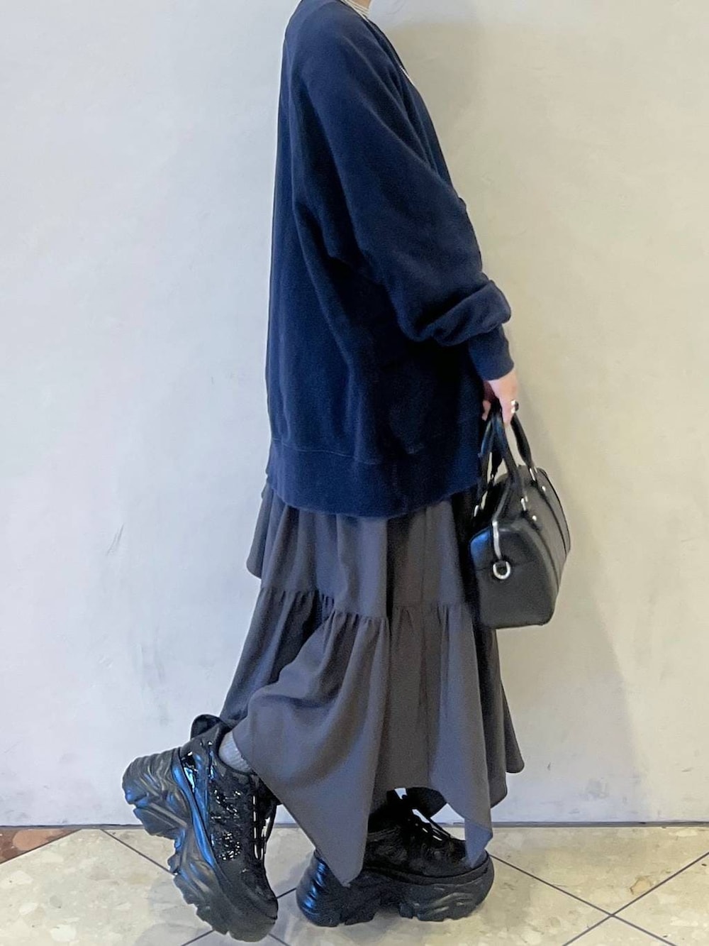 ブラック系のスニーカー、ブルー系のスウェット、グレー系のスカートを着用したレディースの冬コーディネートの3枚目の写真