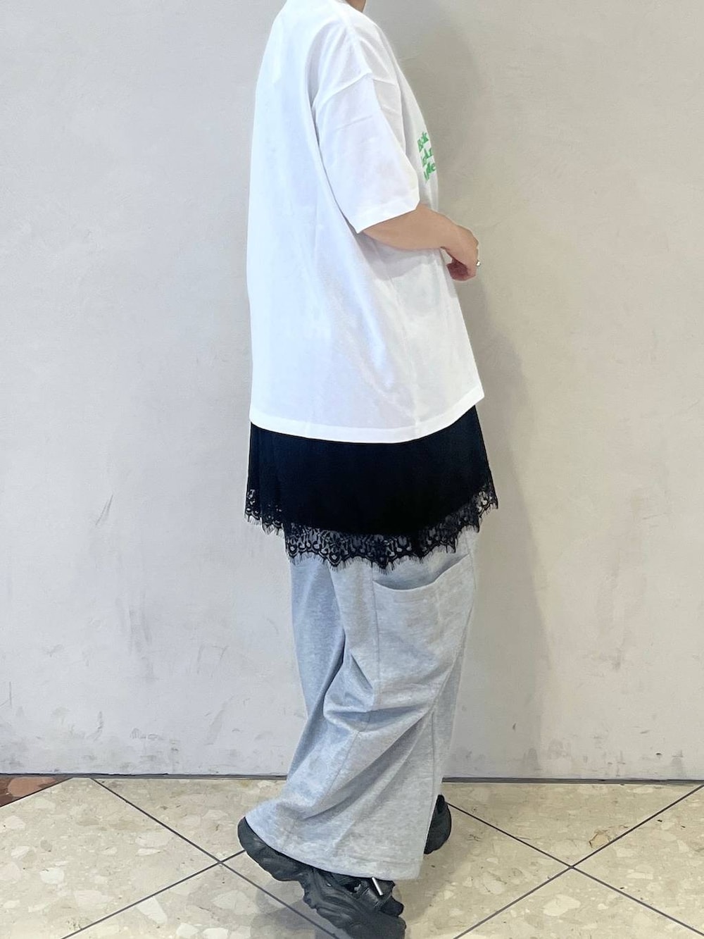 ブラック系のショルダーバッグ、ブラック系のサンダル、ホワイト系のTシャツ/カットソーを着用したレディースの夏コーディネートの2枚目の写真