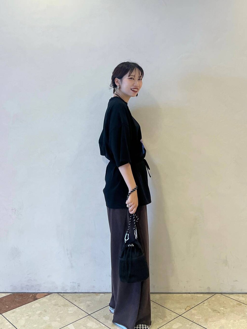 ブラック系のショルダーバッグ、ブラック系のTシャツ/カットソー、ブラウン系のスウェットパンツを着用したレディースの夏コーディネートの3枚目の写真