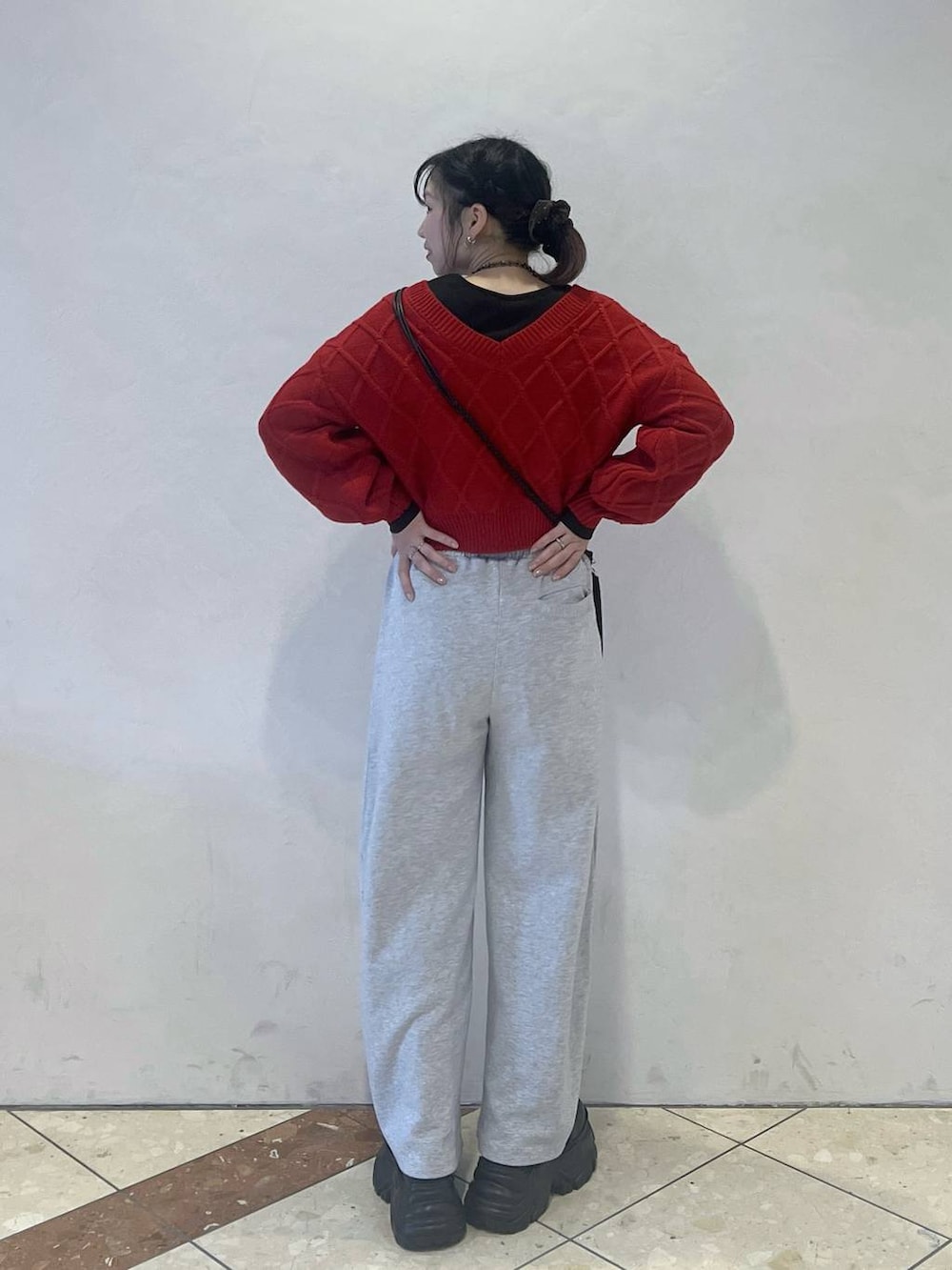 ブラック系のブーツ、グレー系のスウェットパンツ、レッド系のニット/セーターを着用したレディースの冬コーディネートの3枚目の写真