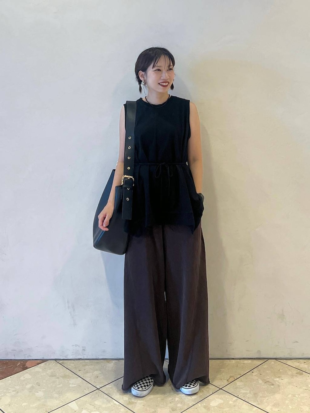 ブラック系のショルダーバッグ、ブラック系のTシャツ/カットソー、ブラウン系のスウェットパンツを着用したレディースの夏コーディネートの2枚目の写真