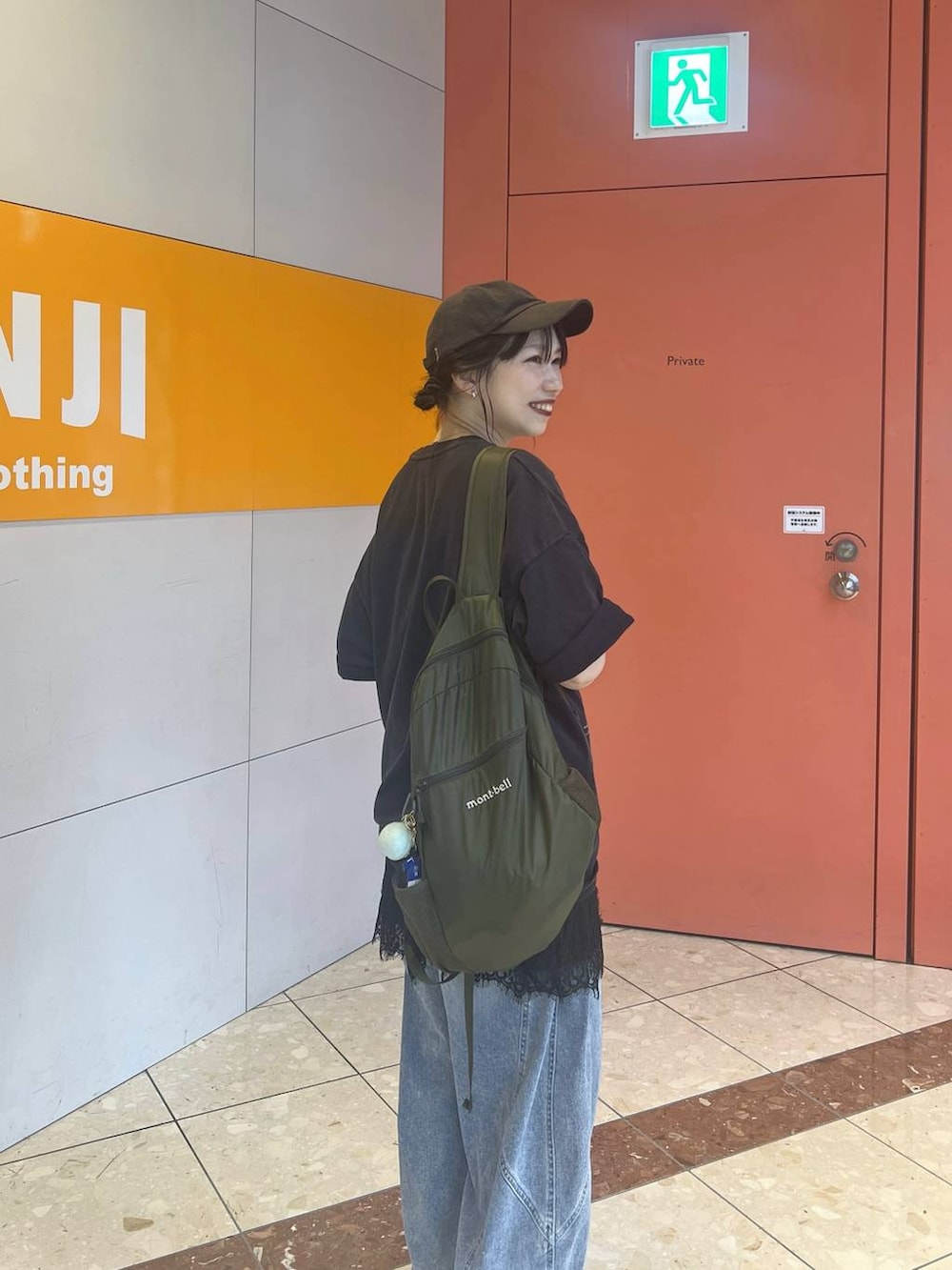 ブルー系のデニムパンツ、ブルー系のTシャツ/カットソー、ブラック系のワンピースを着用したレディースの夏コーディネートの2枚目の写真