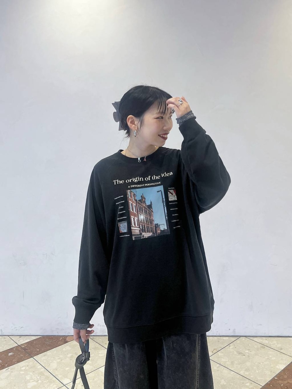 ブラック系のデニムパンツ、グレー系のTシャツ/カットソー、グレー系のショルダーバッグを着用したレディースの春コーディネートの2枚目の写真