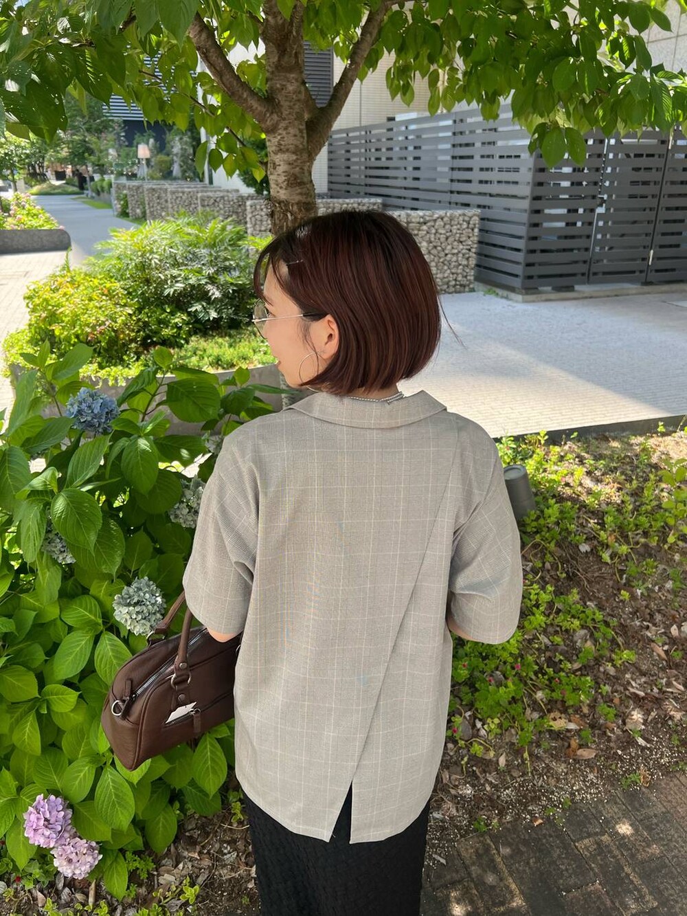 ブラック系のタンクトップ、ブラウン系のショルダーバッグ、ベージュ系のテーラードジャケットを着用したレディースの夏コーディネートの4枚目の写真