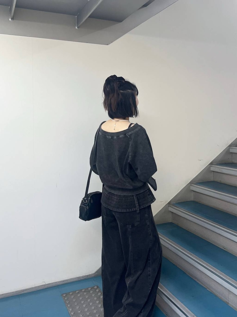 ブラック系のデニムパンツ、ブラック系のTシャツ/カットソー、ブラック系のショルダーバッグを着用したレディースの夏コーディネートの4枚目の写真