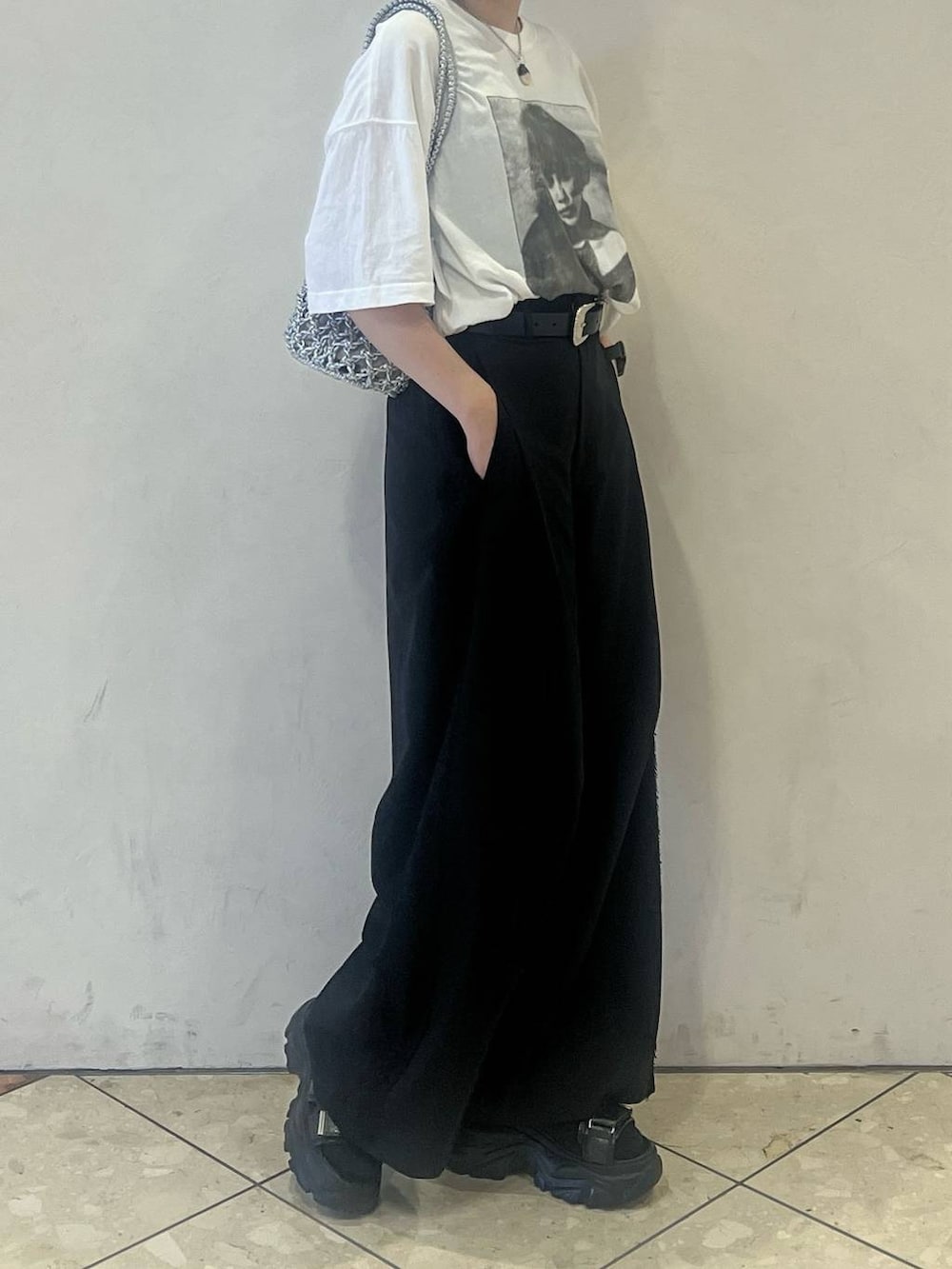 シルバー系のショルダーバッグ、ブラック系のサンダル、ホワイト系のTシャツ/カットソーを着用したレディースの春コーディネートの2枚目の写真