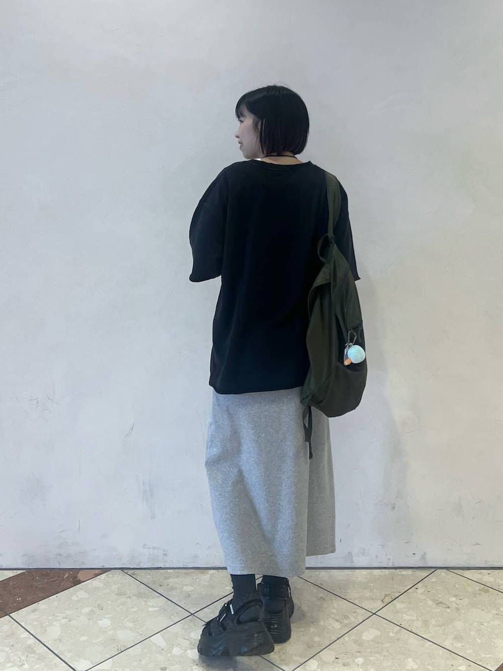 ブラック系のサンダル、ブラック系のTシャツ/カットソー、グレー系のワンピースを着用したレディースの春コーディネートの3枚目の写真