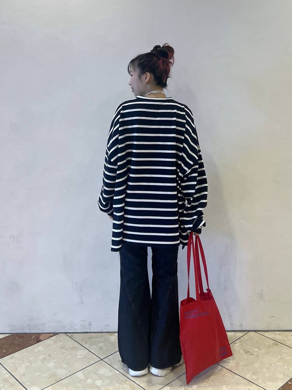 ブルー系のTシャツ/カットソー、ブルー系のデニムパンツ、シルバー系のスニーカーを着用したレディースの秋コーディネートの2枚目の写真