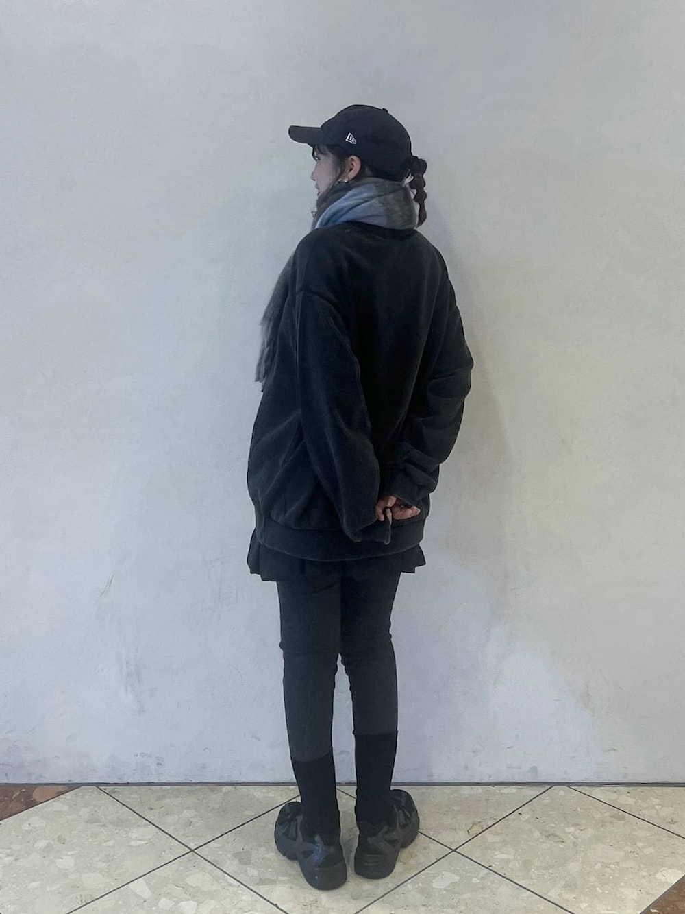 グレー系のスウェット、ブルー系のキャップ、グレー系のレギンス/スパッツを着用したレディースの秋コーディネートの2枚目の写真