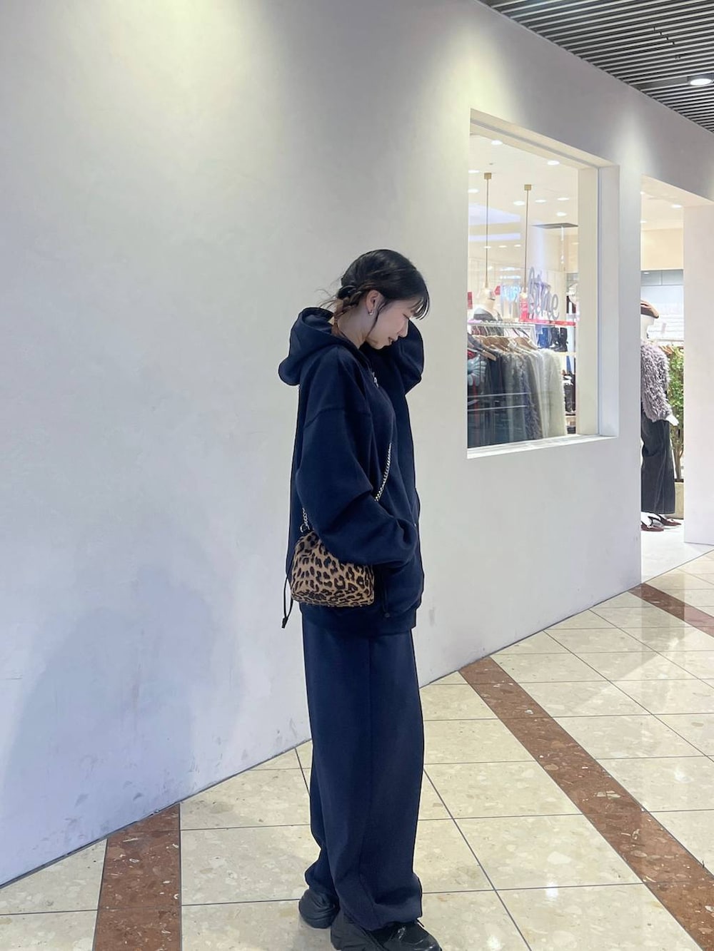 ブラック系のブーツ、その他のハンドバッグ、ブルー系のパーカーを着用したレディースの冬コーディネートの4枚目の写真