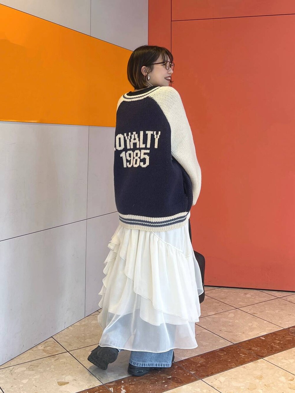 ブラック系のその他シューズ、ブラック系のTシャツ/カットソー、ブルー系のデニムパンツを着用したレディースの冬コーディネートの2枚目の写真