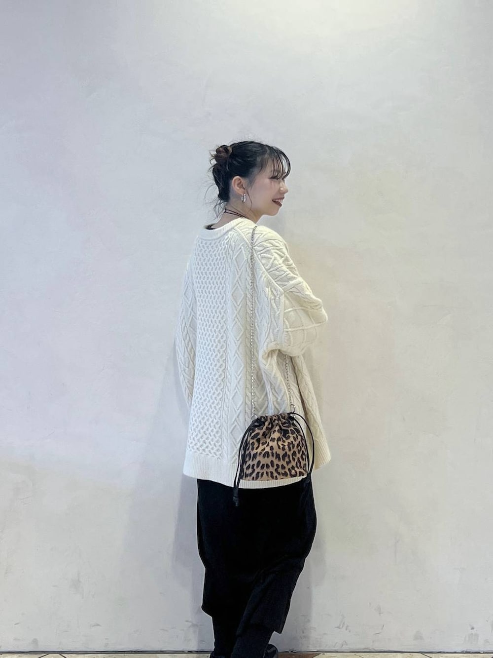 ホワイト系のニット/セーター、ブラック系のスカートを着用したレディースの冬コーディネートの2枚目の写真