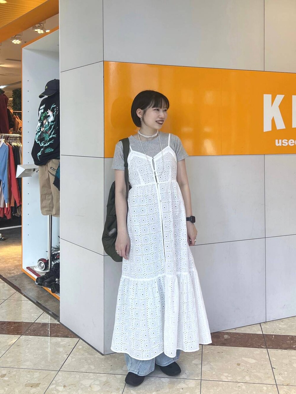 ブラック系のスニーカー、ブルー系のデニムパンツ、グレー系のTシャツ/カットソーを着用したレディースの春コーディネートの2枚目の写真