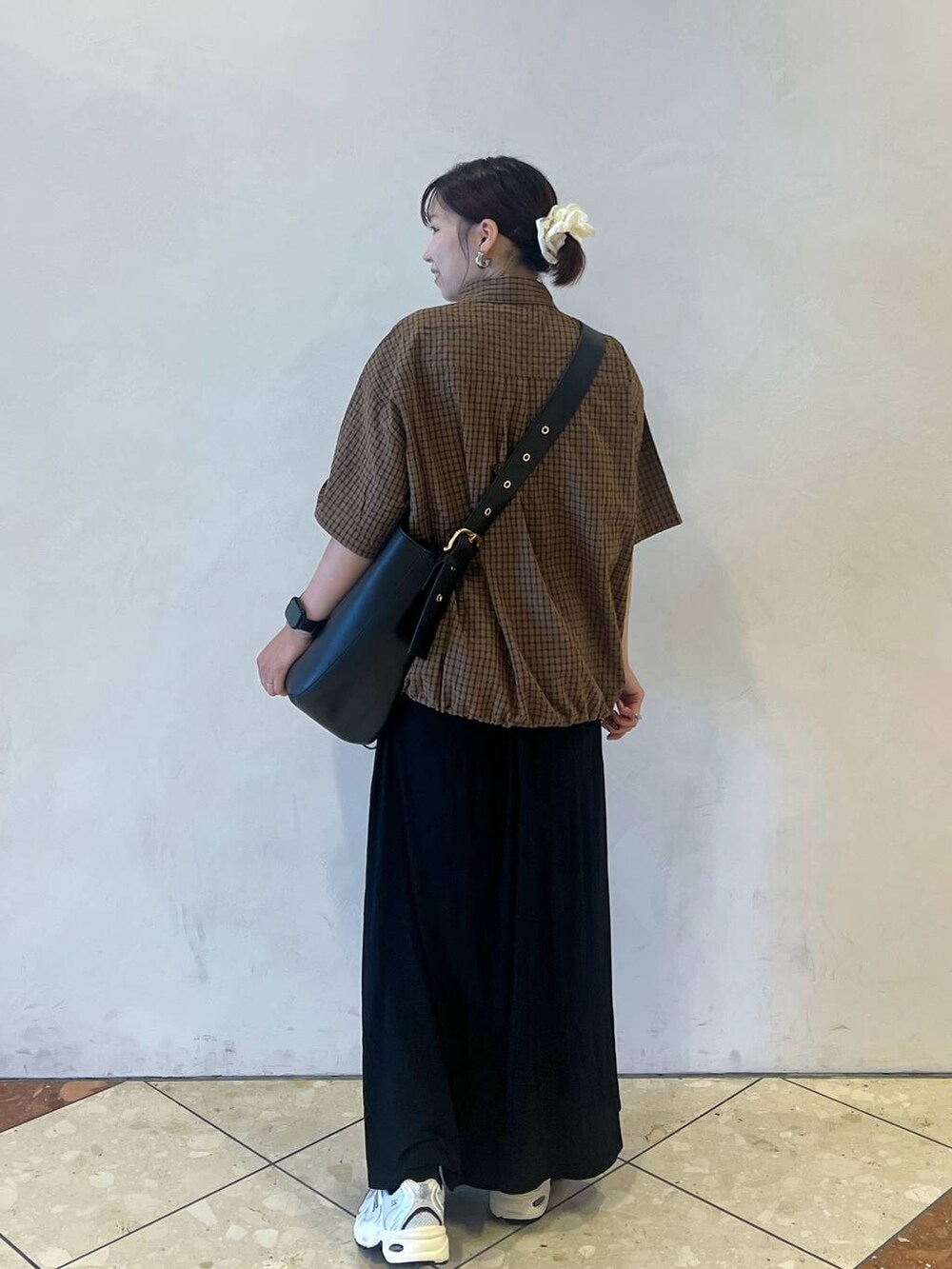 ブラック系のショルダーバッグ、ブラック系のスカート、ブラウン系のシャツ/ブラウスを着用したレディースの夏コーディネートの2枚目の写真