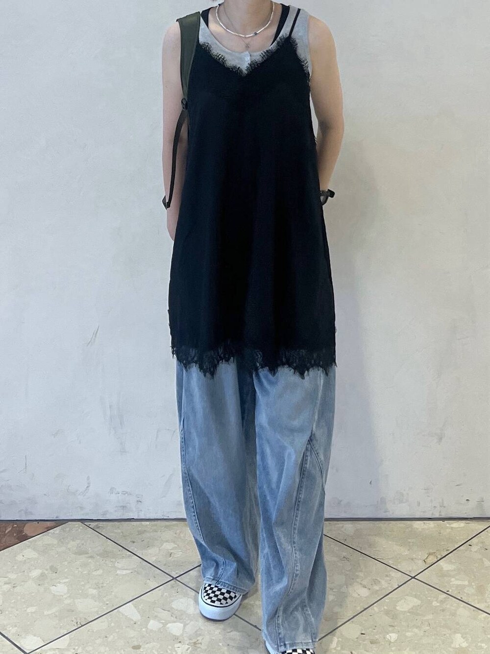 ブルー系のデニムパンツ、グレー系のタンクトップ、ブラック系のワンピースを着用したレディースの夏コーディネートの3枚目の写真