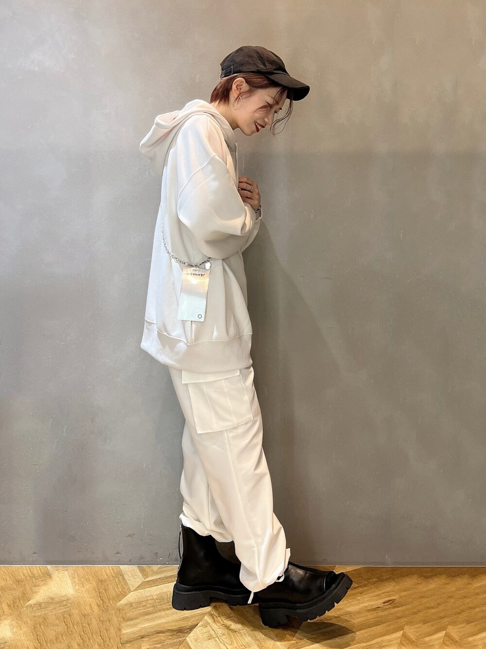 ホワイト系のカーゴパンツ、ブラック系のサンダル、ホワイト系のパーカーを着用したレディースの冬コーディネートの2枚目の写真