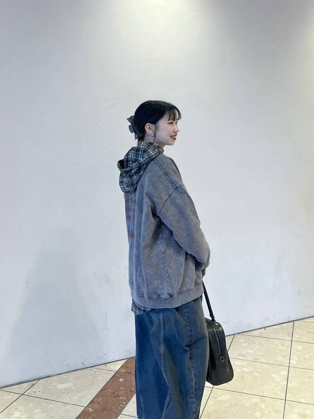 ブラック系のボストンバッグ、ブルー系のスラックス、グレー系のスウェットを着用したレディースの冬コーディネートの2枚目の写真