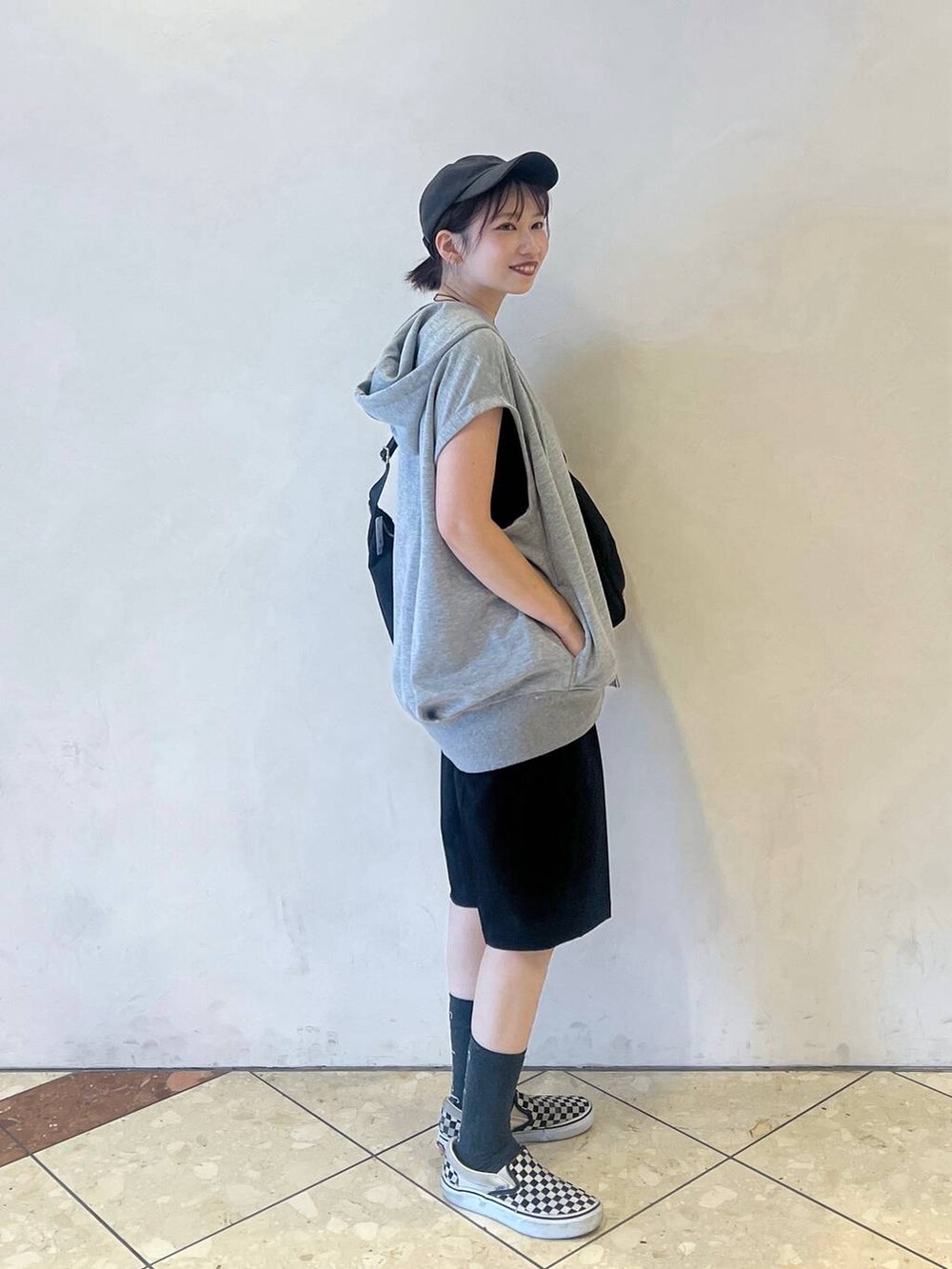 ブラック系のショルダーバッグ、ブラック系のスラックス、グレー系のTシャツ/カットソーを着用したレディースの夏コーディネートの2枚目の写真