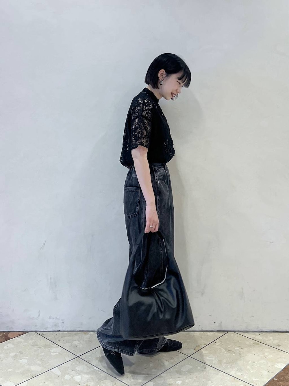 ブラック系のシャツ/ブラウス、ブラック系のトートバッグ、ブラック系のデニムパンツを着用したレディースの春コーディネートの2枚目の写真